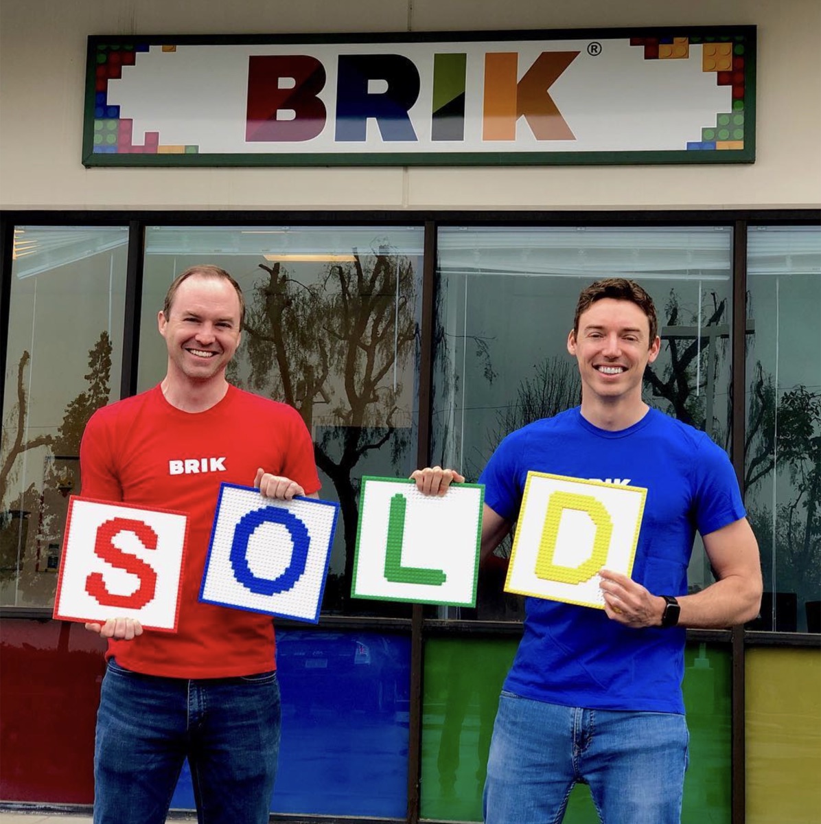Holding SOLD spelled out in brick panels outside the BRIK store